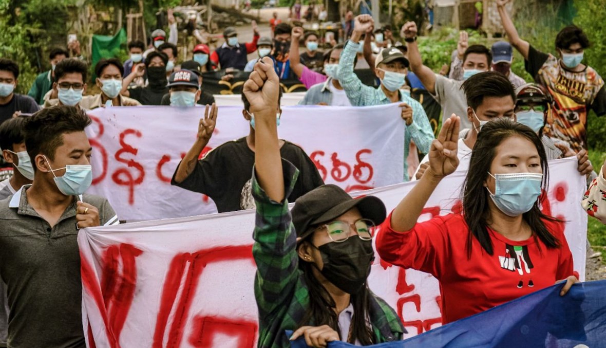 متظاهرون في ماندالاي يشاركون في مسيرة احتجاجية ضد الانقلاب العسكري (11 حزيران 2021، أ ف ب). 