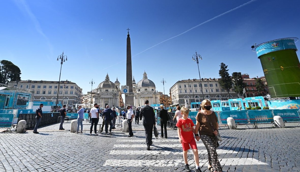 أشخاص يمشون في بيازا ديل بوبولو في روما (11 حزيران 2021، أ ف ب).  