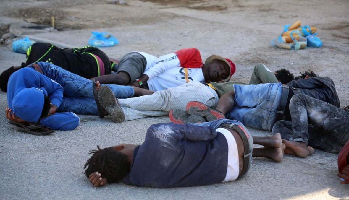 مهاجرون أفارقة أنقذهم الجيش التونسي، يستريحون في ميناء القطيف في بن قردان جنوب تونس (11 حزيران 2021، أ ف ب).