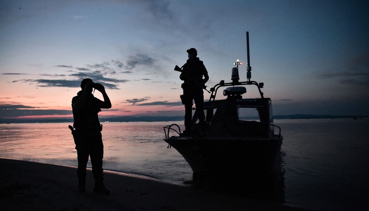 شرطيان يقومان بدورية في دلتا نهر إيفروس على طول الحدود اليونانية التركية (8 حزيران 2021، أ ف ب).