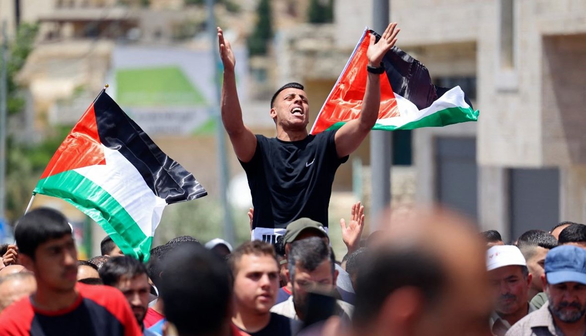 فلسطينيون يتظاهرون ضد الاستيطان الإسرائيلي في قرية سلواد قرب رام الله بالضفة الغربية المحتلة (11 حزيران 2021، أ ف ب). 