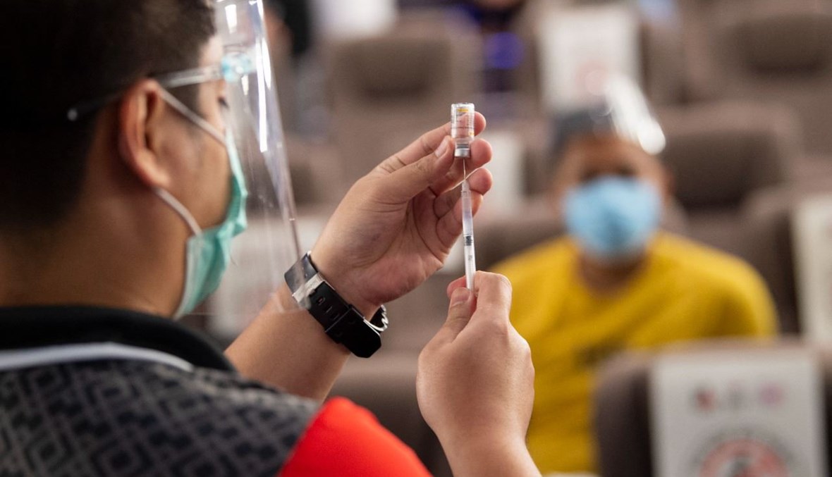 عامل صحي يجهز حقنة بلقاح كورونا في قاعة سينما تم تحويلها مركز تطعيم في مدينة تاجويغ بضواحي مانيلا (14 حزيران 2021، ا ف ب). 