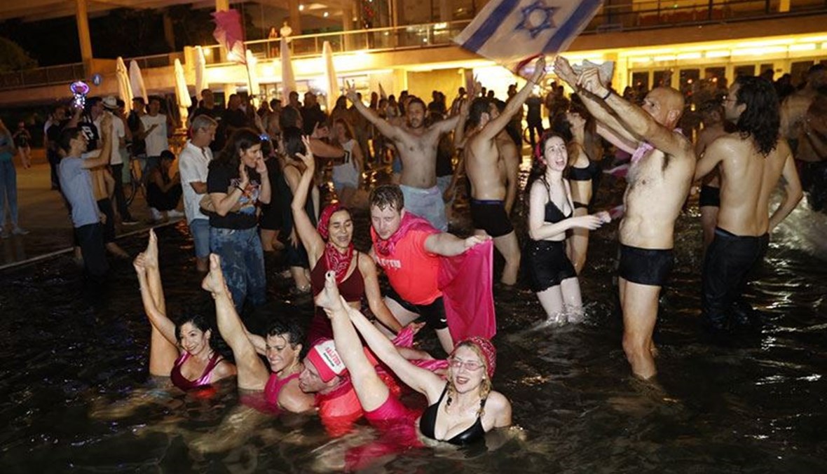 اسرائيليون يحتفلون بالحكومة الجديدة في ساحة رابين بتل أبيب ليل الاحد. (أ ف ب)