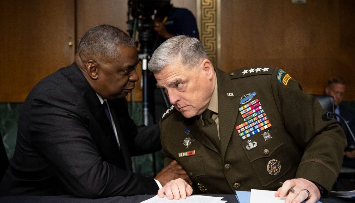 أوستن (الى اليسار) يتحدث الى الجنرال ميلي قبل الادلاء بشهادتهما في جلسة استماع في مبنى الكابيتول هيل في واشنطن (17 حزيران 2021، أ ف ب). 