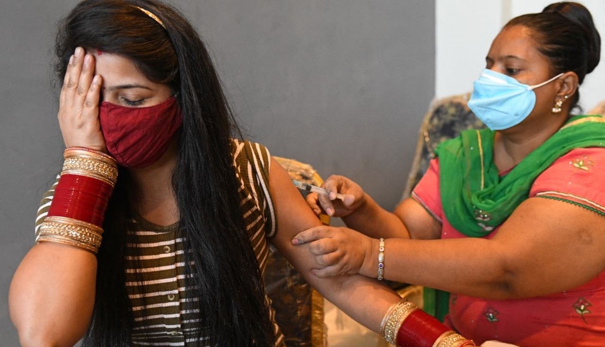 امرأة تتلقى لقاح كورونا في مركز تطعيم أقيم في صالون في أمريتسار بالهند (20 حزيران 2021، أ ف ب). 