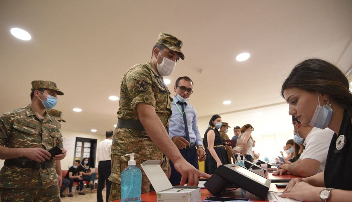 عسكري يستعد للتصويت في مركز اقتراع في يريفان (20 حزيران 2021، أ ف ب).