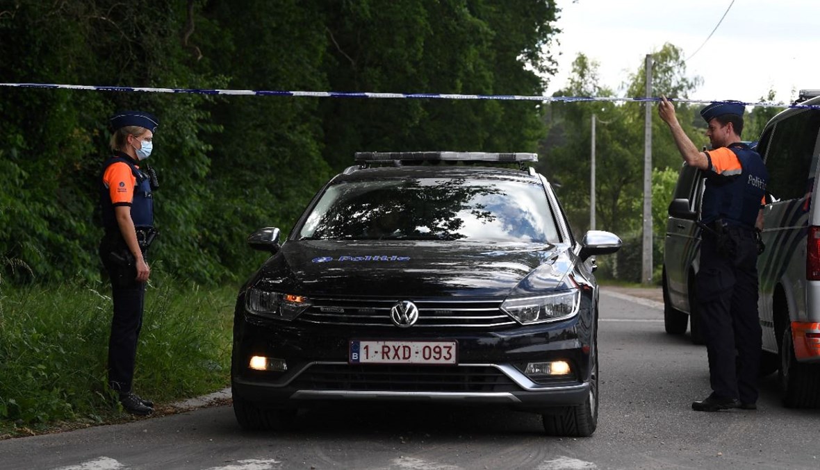 سيارة للشرطة بلجيكية تغادر الموقع الذي عُثِر فيه على الجثة في ديلسربوس بالقرب من ديلسن-ستوكم (20 حزيران 2021، أ ف ب). 