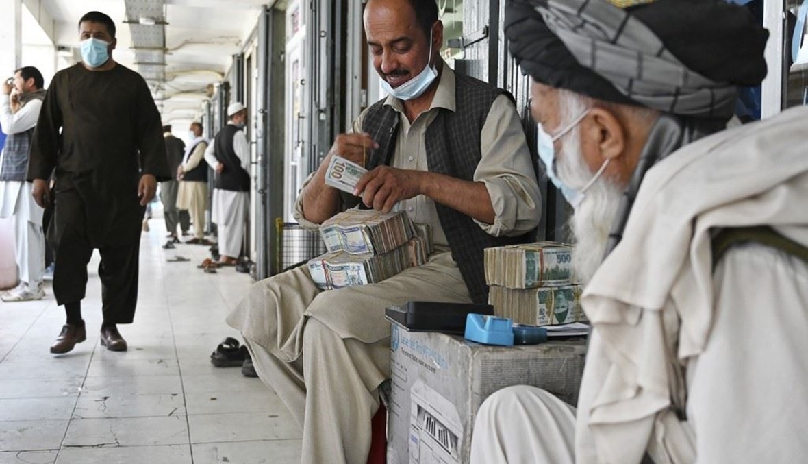 صراف أفغاني يعد دولارات أميركية في سوق شاهزاد للصيرفة في كابول الاثنين.   (أ ف ب)  