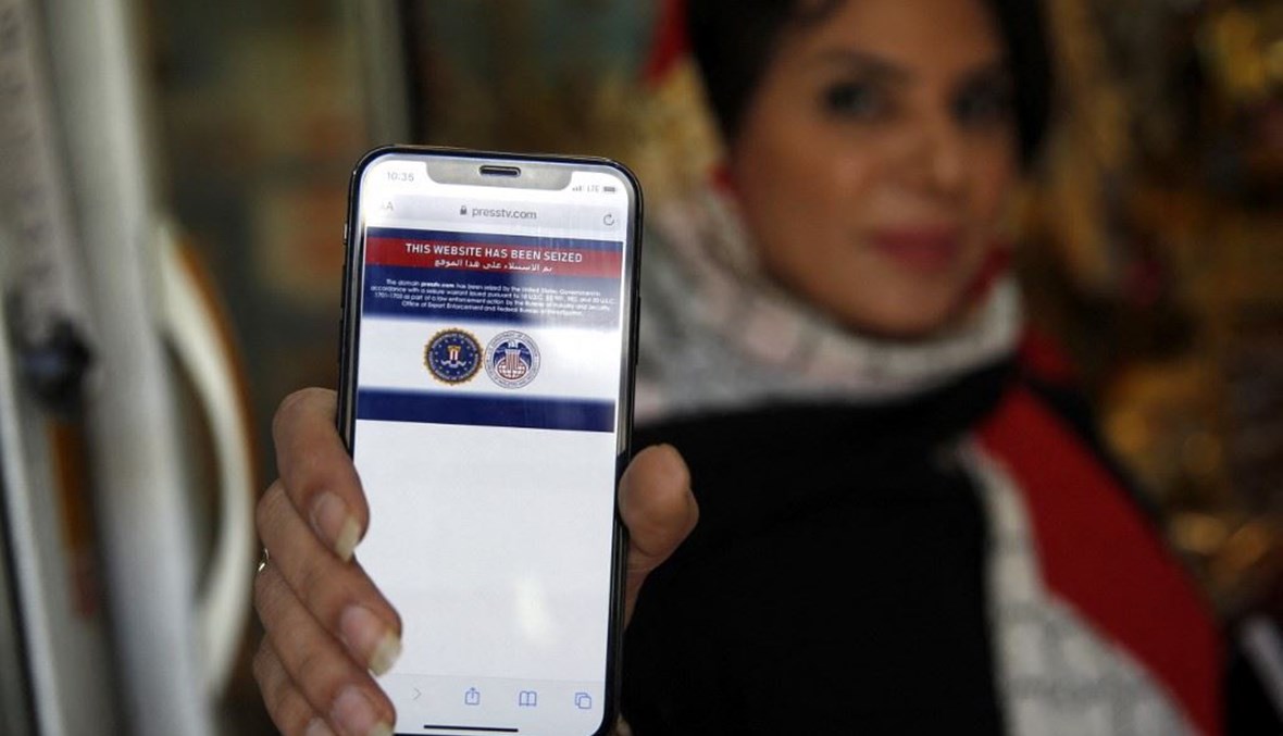 إيرانية تظهر على هاتفها رسالة بالانكليزية عن سيطرة الولايات المتحدة على الموقع الإلكتروني التابع لقناة “برس تي في” الإيراني أمس. (أ ف ب)