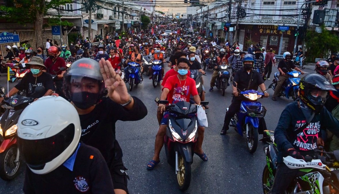 متظاهر مؤيد للديموقراطية يؤدي التحية بثلاثة أصابع خلال مسيرة مناهضة للحكومة في بانكوك (24 حزيران 2021، أ ف ب). 