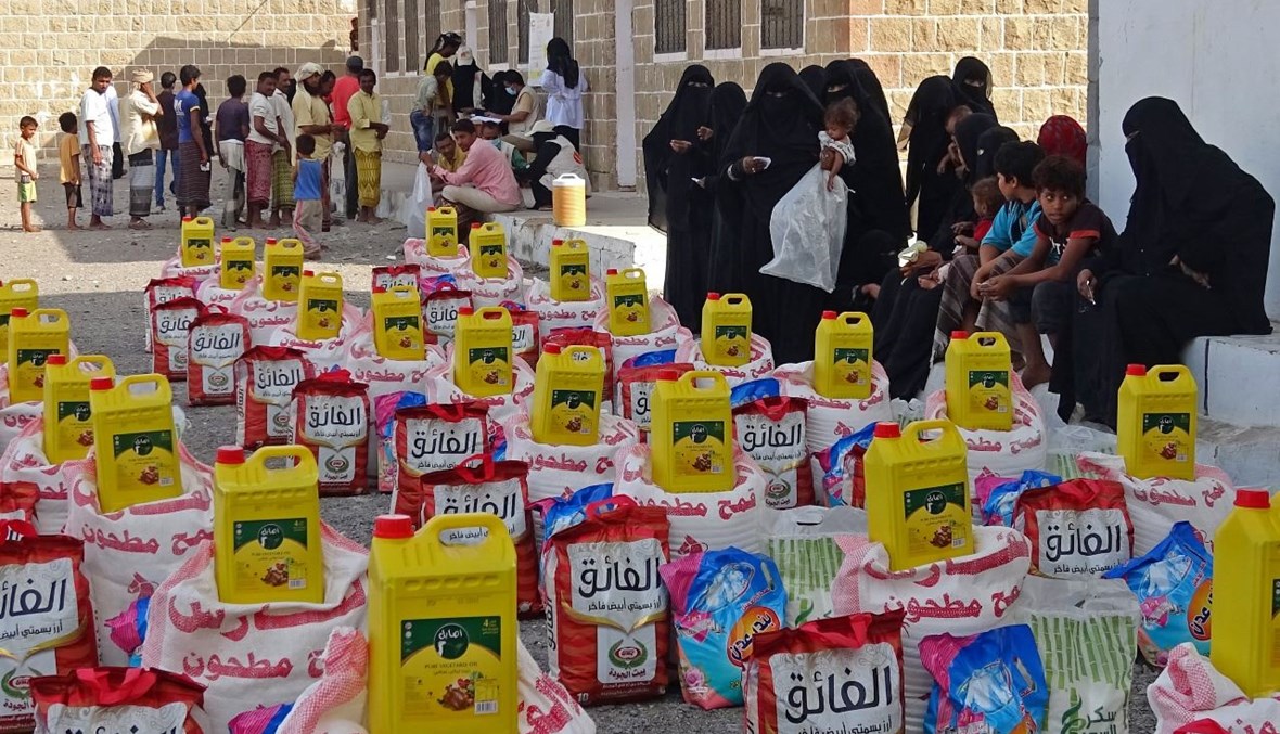 نازحون يمنيون يتلقون مساعدات غذائية في مديرية التحيتا بمحافظة الحديدة غرب اليمن (30 حزيران 2021، ا ف ب). 