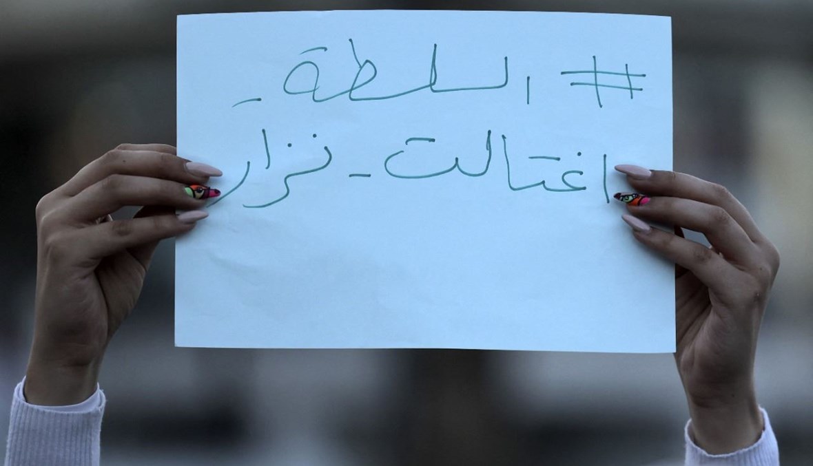 امرأة ترفع لافتة كتب عليها "السلطة اغتالت نزار"، خلال تظاهرة في رام الله بالضفة الغربية المحتلة، احتجاجا على مقتل الناشط نزار بنات (30 حزيران 2021، أ ف ب). 
