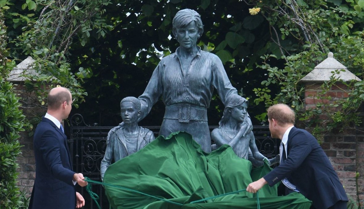 الأميران وليام وهاري يزيحان الستارة عن تمثال والدتهما الأميرة ديانا في حديقة صنكن في قصر كينزنغتون في وسط لندن (1 تموز 2021، أ ف ب). 