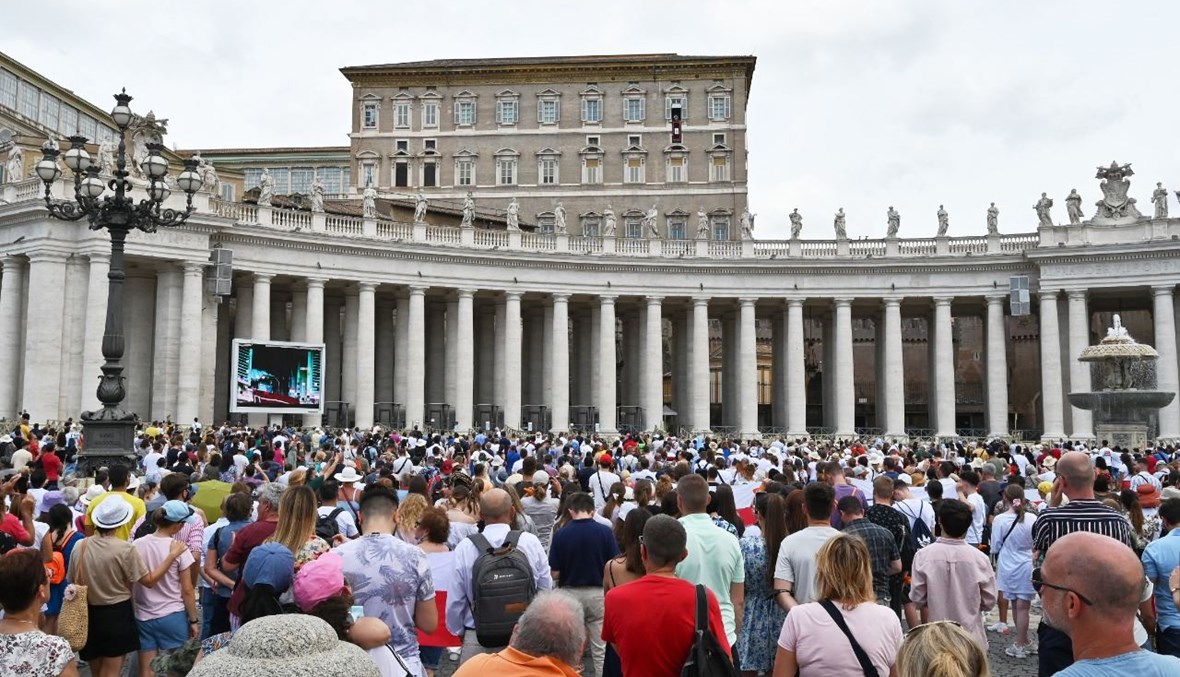 مؤمنون يشاركون في صلاة التبشير الملائكي التي يلقيها البابا فرنسيس من نافذة مكتبه المطل على ساحة القديس بطرس في الفاتيكان (4 تموز 2021، أ ف ب). 