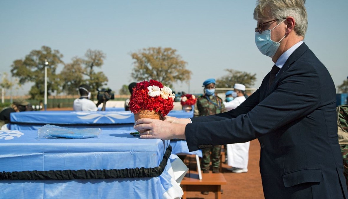 وكيل الأمين العام للأمم المتحدة لعمليات السلام جان بيار لاكروا يضع زهورا على نعش جندي من قوة حفظ السلام في مالي (مينوسما) خلال مراسم دفن في باماكو (29 ك2 2021، أ ف ب). 