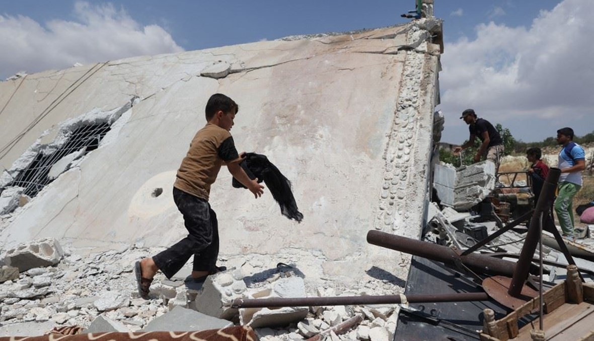طفل ينقذ متعلقاته من منزل دمره هجوم صاروخي روسي في منطقة جبل الزاوية جنوب محافظة إدلب (أ ف ب). 