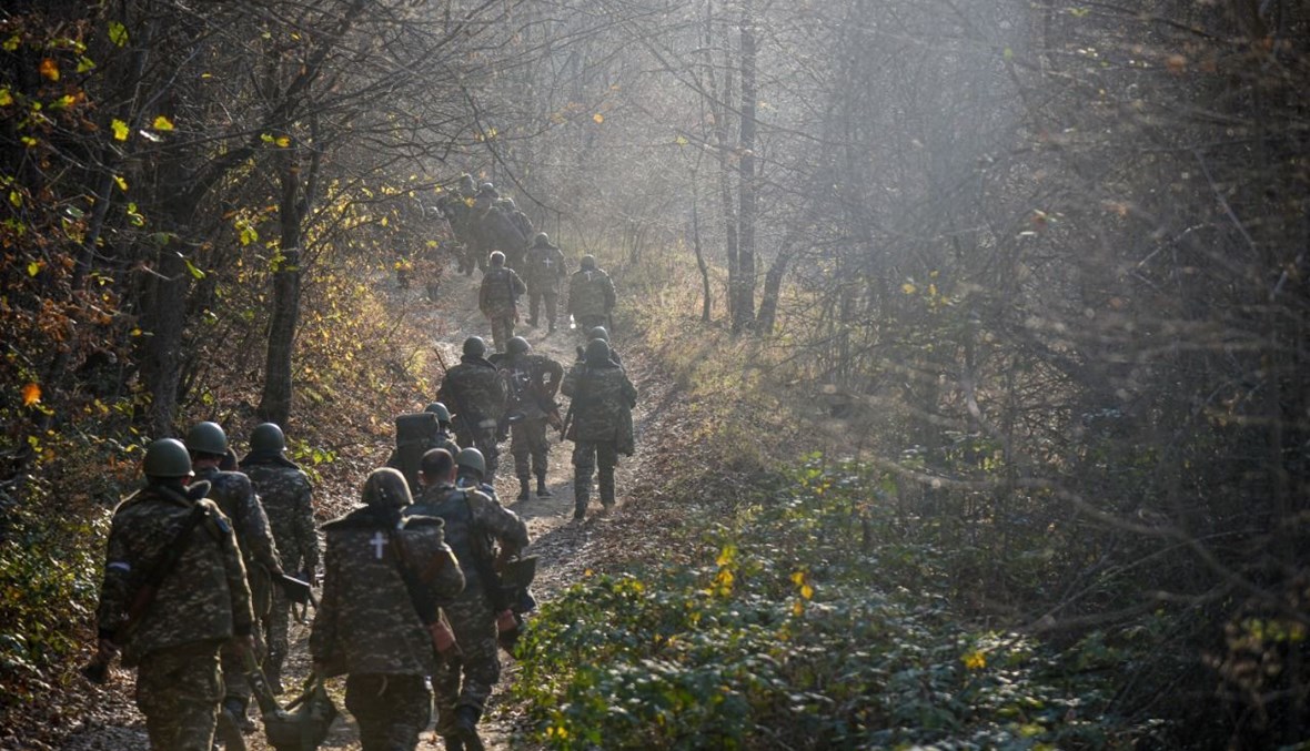 متطوعون عسكريون يسيرون على طريق وسط غابات في منطقة شوشا (31 ت1 2020، أ ف ب).