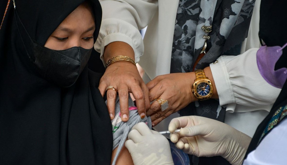 امرأة تتلقى لقاح كورونا خلال حملة تطعيم في باندا آتشيه بإندونيسيا (7 تموز 2021، أ ف ب). 