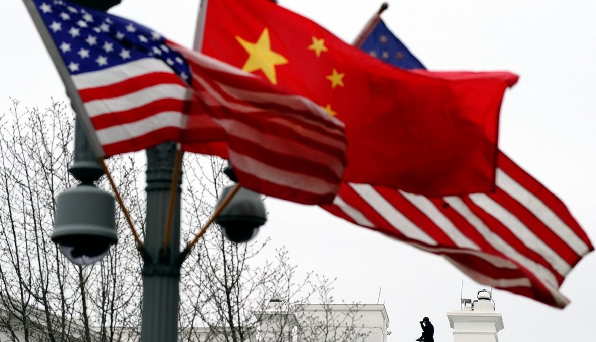 رجل أمن تمركز على سطح البيت الأبيض، بينما تم تزيين عمود الإنارة بالأعلام الصينية والأميركية في واشنطن قبل زيارة للرئيس الصيني هو جينتاو (17 ك2 2011، أ ف ب). 