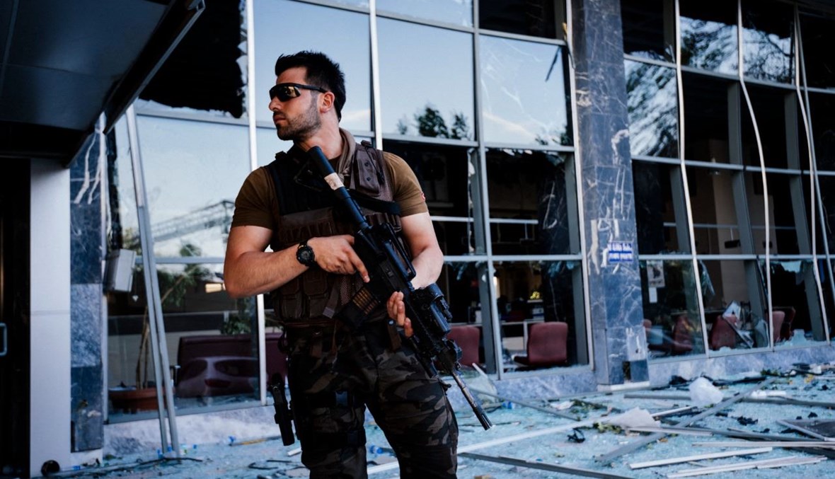 شرطي تركي مسلح وقف أمام مقر شرطة أنقرة المتضرر بعد تفجيره خلال محاولة الانقلاب الفاشلة (19 تموز 2021، أ ف ب). 