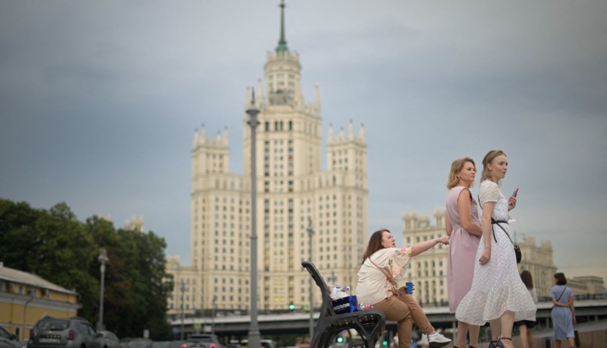 صورة تعبيرية- نساء يمشين على جسر نهر موسكفا في وسط موسكو (15 تموز 2021، أ ف ب). 