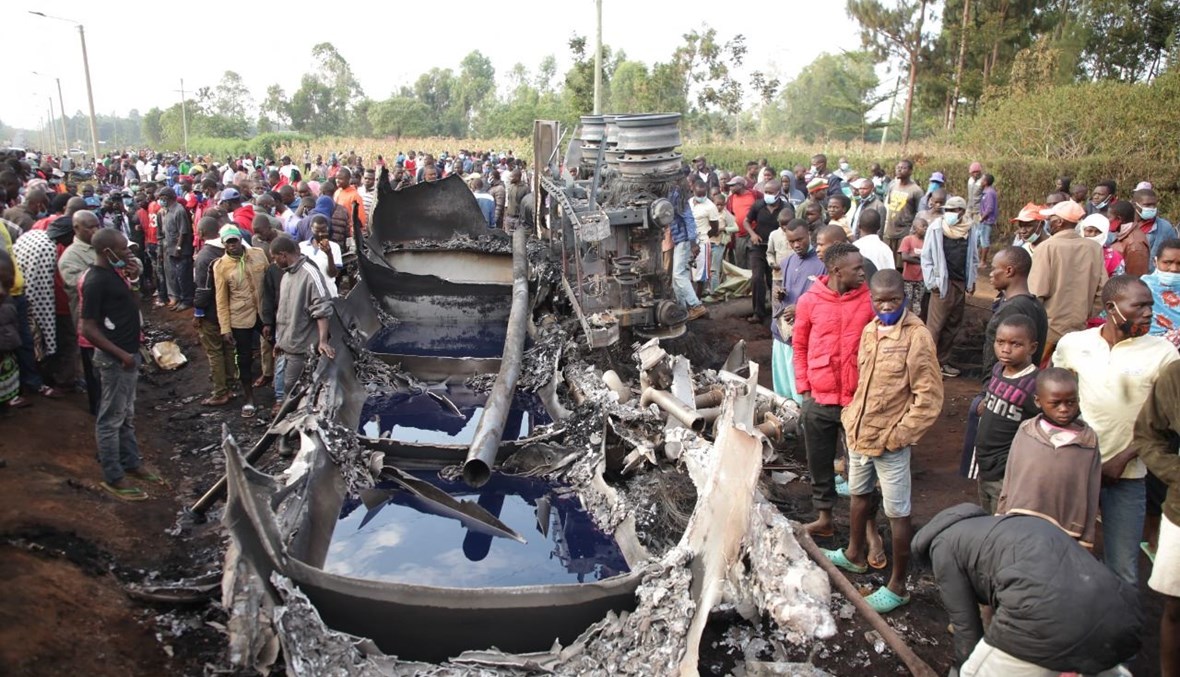 اشخاص تجمعوا حول شاحنة صهريج محترقة اشتعلت فيها النيران بعدما انقلبت في غرب كينيا (18 تموز 2021، أ ف ب).