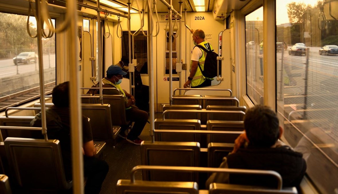 أشخاص يضعون كمامات على الوجه خلال ركوبهم خط مترو سي في ساعة الذروة في لوس أنجليس بكاليفورنيا (16 تموز 2021، أ ف ب). 