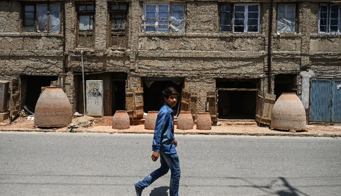 صبي يمر بالقرب من متجر في كابول (18 تموز 2021، أ ف ب). 
