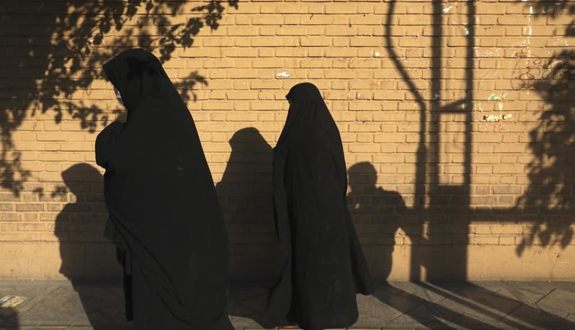 نساء يمشين على الرصيف في شارع بجنوب طهران (20 تموز 2021، أ ب). 