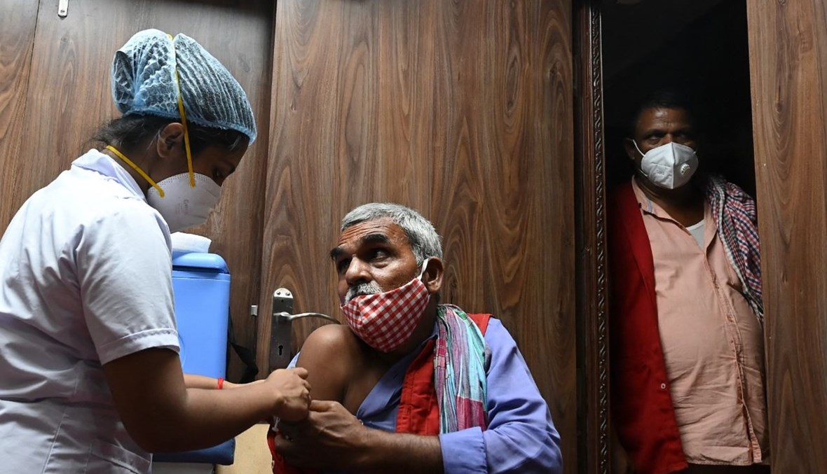 رجل يتلقى لقاح كورونا في مركز تلقيح موقت أقيم في محطة سيلداه للقطارات في كولكاتا بالهند (22 تموز 2021، أ ف ب). 
