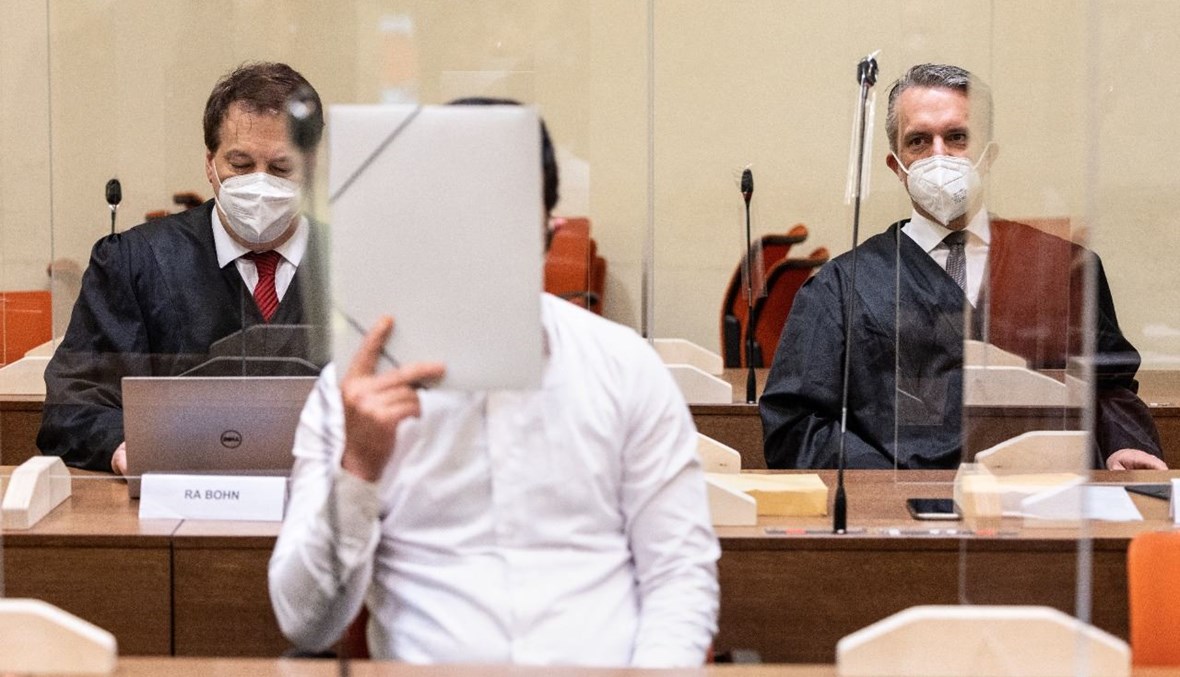 المتهم "محرم. د" (في الوسط) خلال مثوله أمام المحكمة الإقليمية في ميونيخ جنوب ألمانيا (23 تموز 2021، أ ف ب).