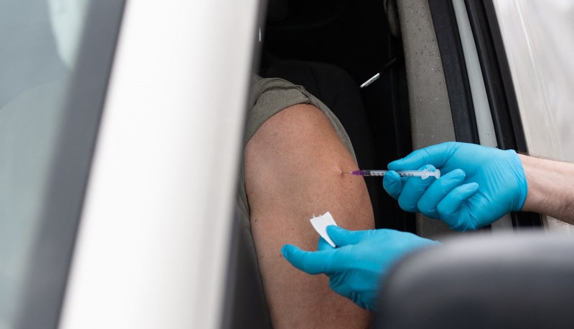 رجل يتلقى لقاح كورونا في سيارته في مركز تطعيم في برلين (17 تموز 2021، أ ف ب). 