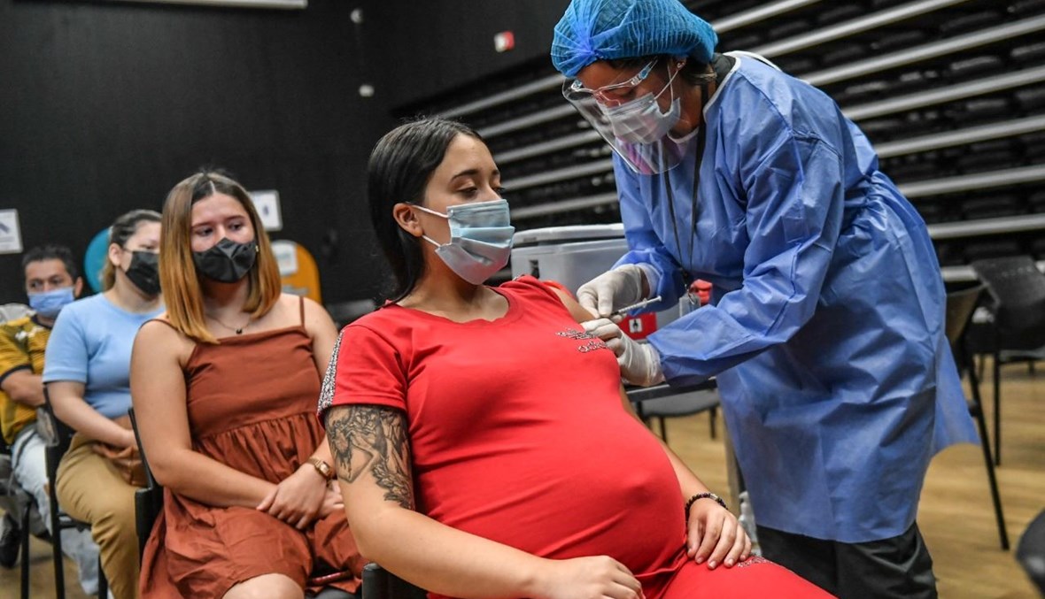 امرأة حامل تتلقى لقاح كورونا في مركز تطعيم في ميديلين بكولومبيا (24 تموز 2021، أ ف ب). 