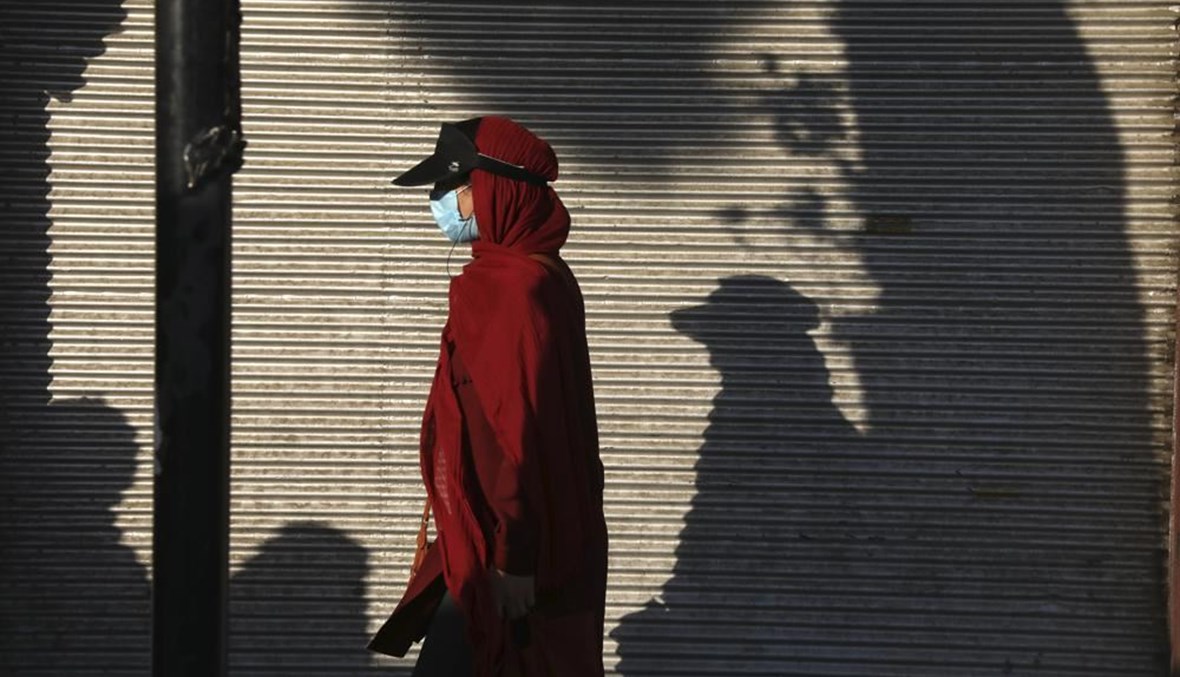 صورة تعبيرية- امرأة تمشي في شارع في جنوب طهران (20 تموز 2021، أ ب). 
