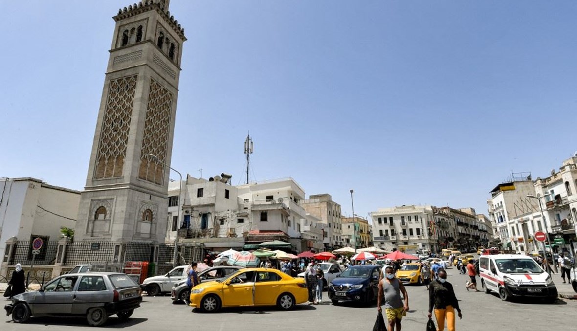 أشخاص يمرون قبالة جامع سيدي بشير في منطقة باب الفلاح في العاصمة التونسية الأربعاء.   (أ ف ب) 