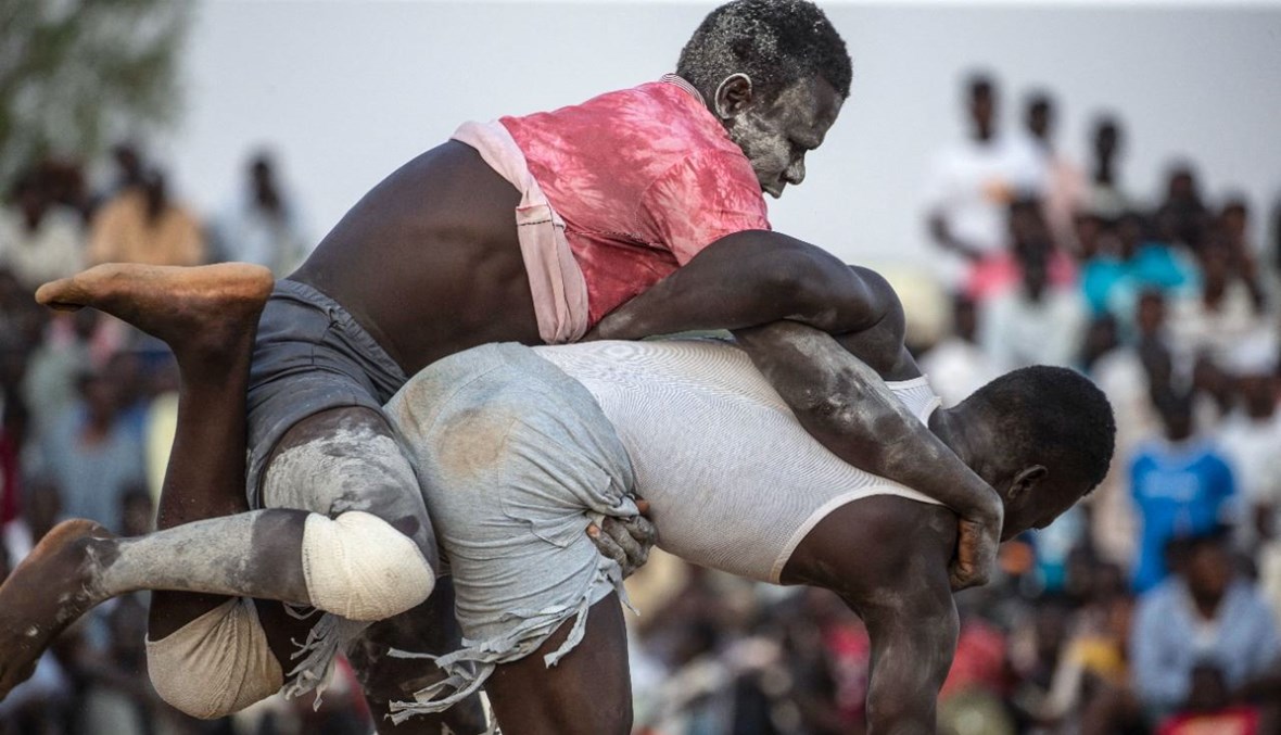 رجلان يتصارعان خلال مسابقة تقليدية لمصارعة النوبة في العاصمة السودانية الخرطوم (30 تموز 2021، أ ف ب).