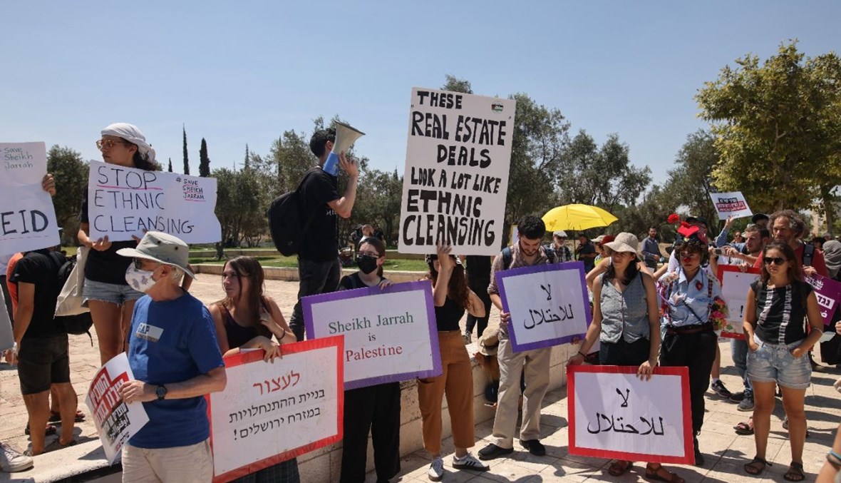 نشطاء فلسطينيون وإسرائيليون وأجانب يرفعون لافتات خلال تظاهرة امام المحكمة العليا الاسرائيلية في القدس احتجاجا على الاحتلال الإسرائيلي والنشاط الاستيطاني (2 آب 2021، أ ف ب). 