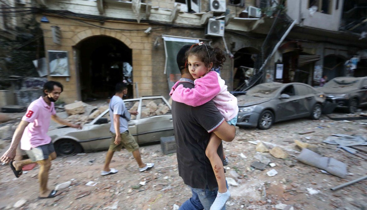 صورة التُقطت بعَيد انفجار بيروت لأب يحمل طفلته