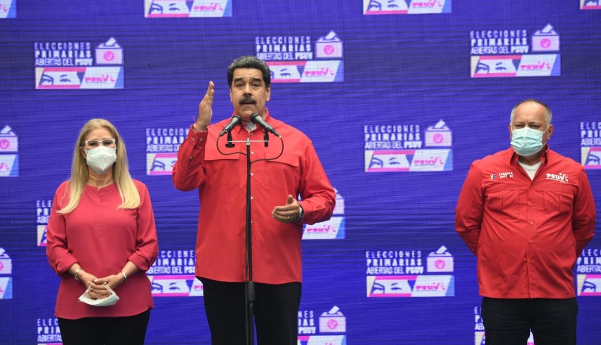 مادورو برفقة زوجته في مركز اقتراع في مدرسة سيمون رودريغيز في فويرتي تيونا بكاراكاس خلال الانتخابات التمهيدية للحزب الاشتراكي الموحد الفنزويلي (8 آب 2021، أ ف ب). 
