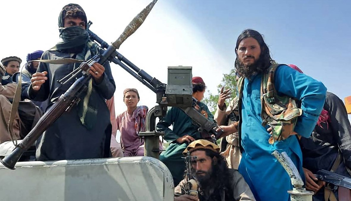 مقاتلون من طالبان جلسوا على عربة في أحد شوارع ولاية لغمان (15 آب 2021، أ ف ب). 