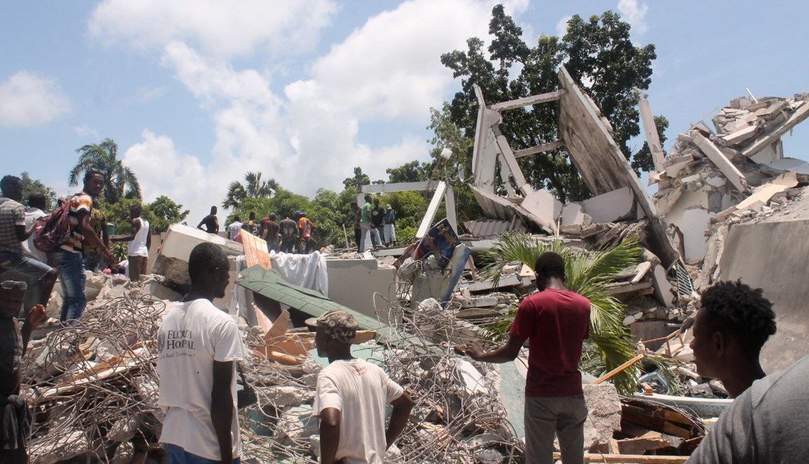 أشخاص يبحثون عن ناجين بين أنقاض فندق مانغير في لي كاي  جنوب غرب هايتي، بعد الزلزال (14 آب 2021ـ أ ف ب). 