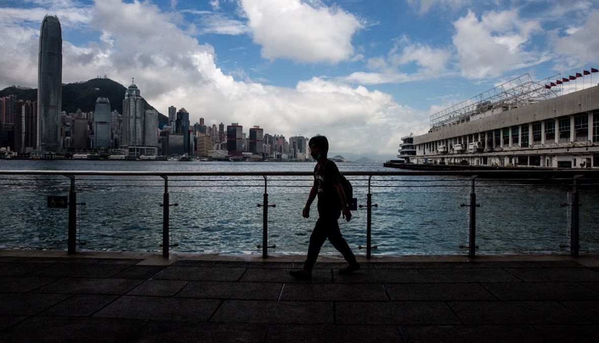 رجل يمشي على رصيف ميناء فيكتوريا في منطقة كولون بهونغ كونغ (16 آب 2021، أ ف ب). 