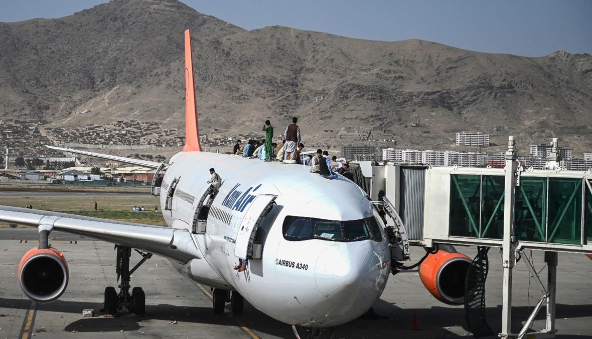 أفغان تسلقوا طائرة خلال انتظارهم في مطار كابول في كابول (16 آب 2021، أ ف ب). 