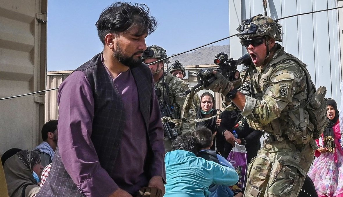 جندي أميركي يصوّب بندقيته نحو أفغاني في مطار كابول في كابول (16 آب 2021، أ ف ب). 