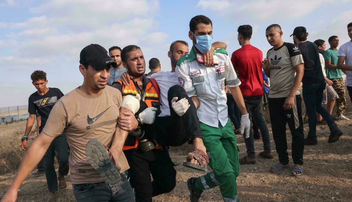 نقل متظاهر فلسطيني أصيب خلال مواجهات مع قوات الأمن الإسرائيلية في غزة (أ ف ب).
