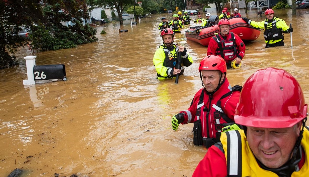 رجال إنقاذ خلال إخلاء سكان في هيلميتا بنيو جيرسي (22 آب 2021، أ ف ب). 