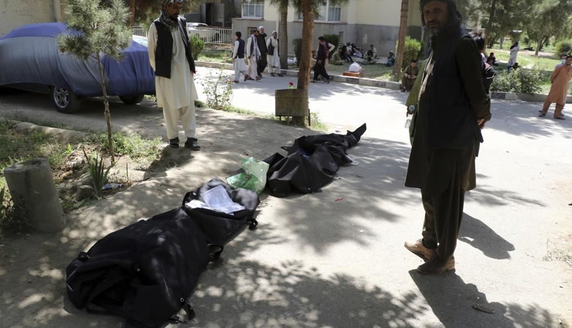 رجال أفغان يحاولون التعرف الى جثث في مستشفى في كابول (27 آب 2021، أ ب).