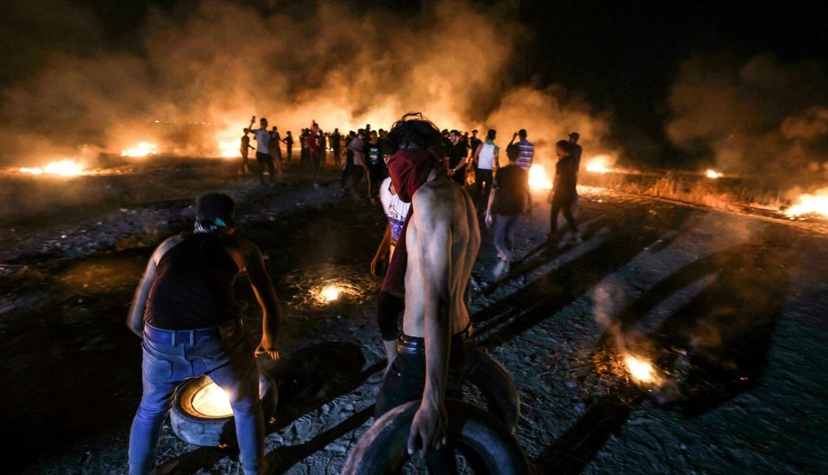 محتجون فلسطينيون يحرقون إطارات خلال تظاهرة على السياج الحدودي بين اسرائيل وقطاع غزة (أ ف ب).
