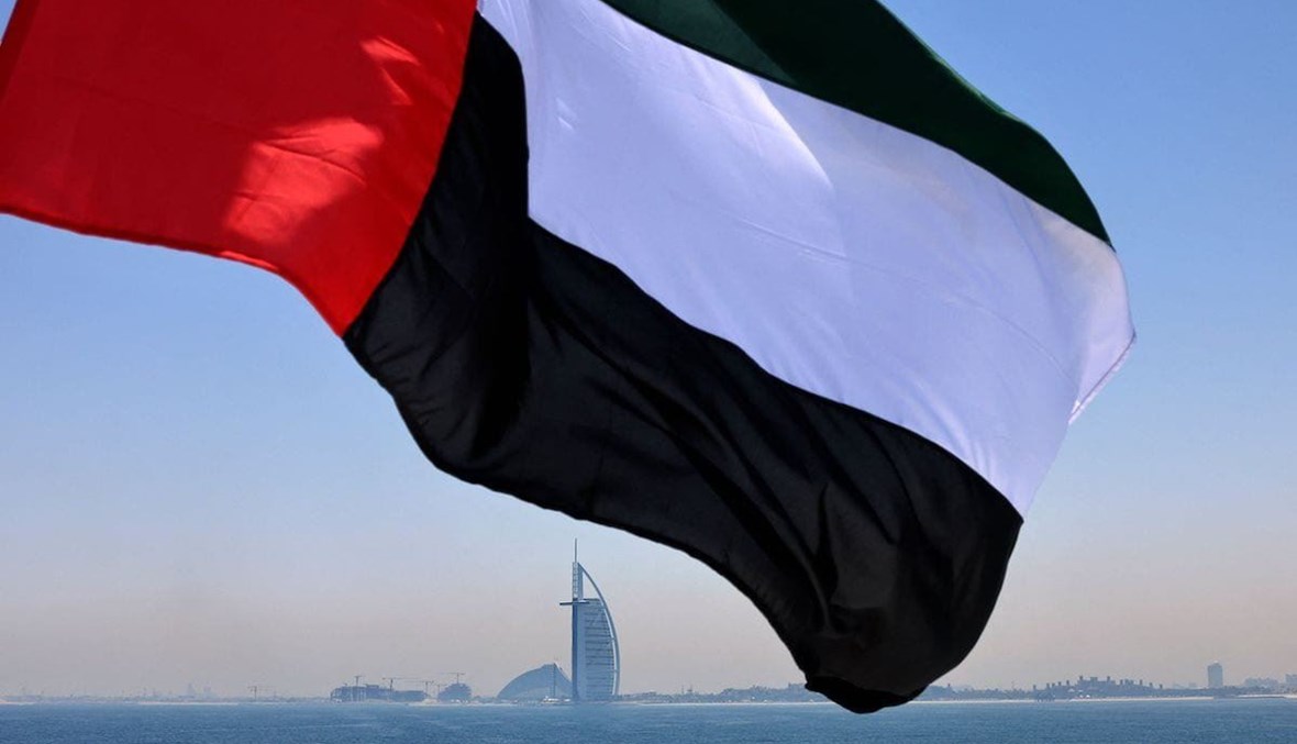 علم إماراتيّ يرفرف فوق خليج دبي وفندق برج العرب (تعبيرية- أ ف ب).