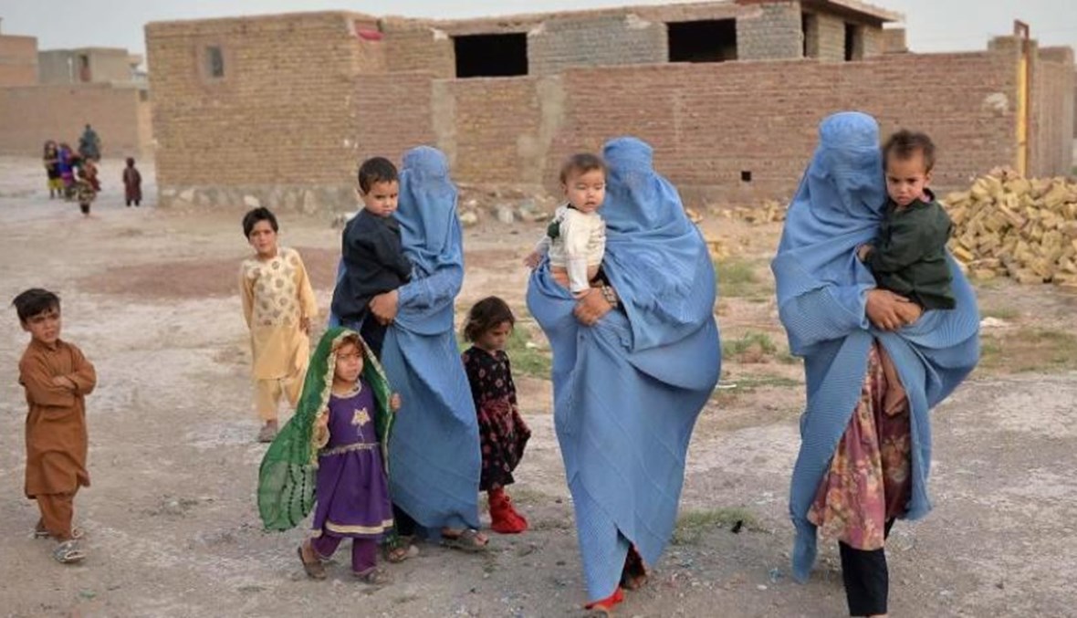 أفراد من عائلات فرّت من القتال الدائر في إقليم بادغيس بين القوات الحكومية ومقاتلي "طالبان" (أ ف ب).